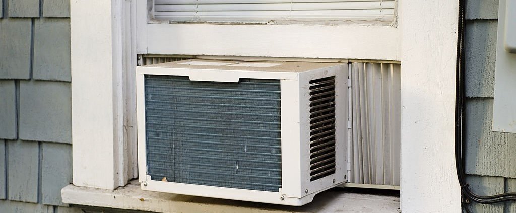 10 Signs Your Air Conditioner Needs Repair 1 An air conditioning unit sticking out a window.
