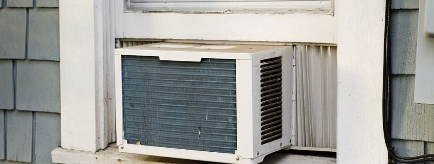 10 Signs Your Air Conditioner Needs Repair 1 An air conditioning unit sticking out a window.